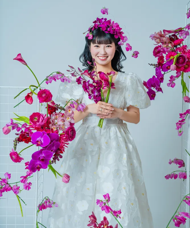 生花のアレンジに囲まれて花束を抱える花嫁（Bouquet シーン）