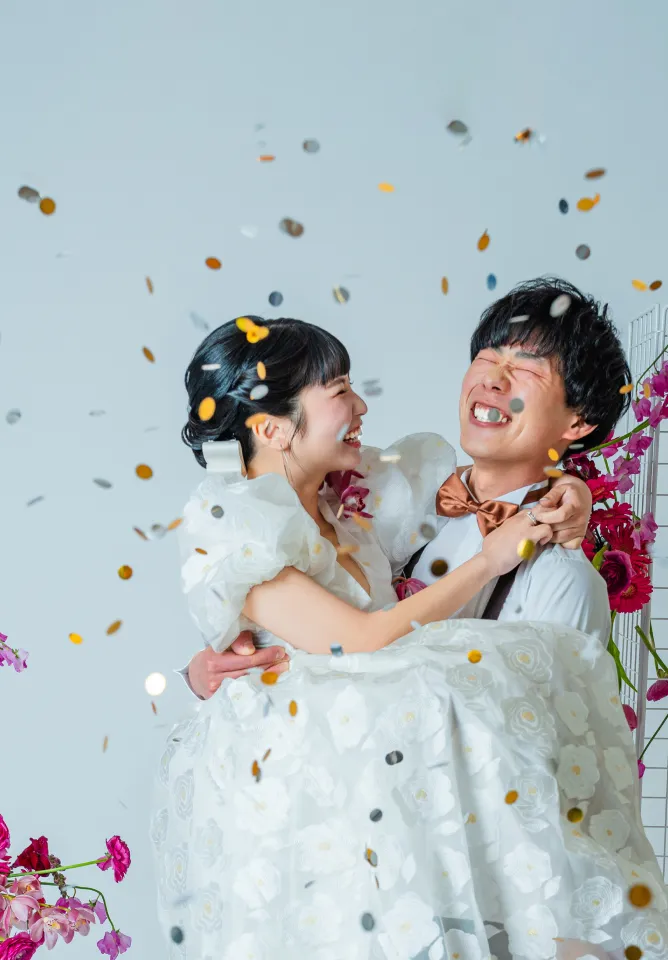 舞い散るコンフェッティの中で抱き合って笑う新郎新婦（Confetti シーン）