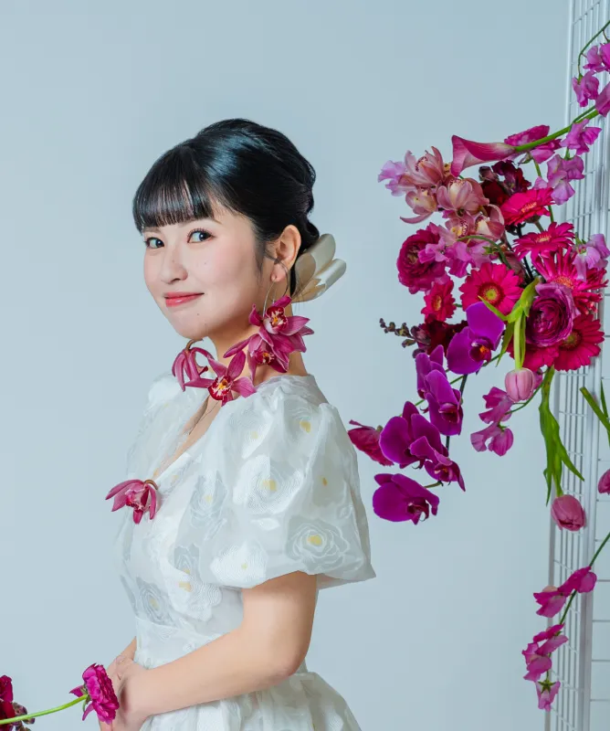 生花のアレンジを背に振り向く花嫁（Flower Crowns シーン）