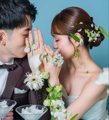 白い花を添えた手を顔の前で重ねる新郎新婦（Hands with flowers シーン）