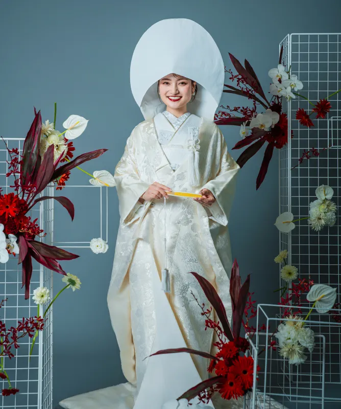 綿帽子に白無垢をまとい微笑む和装の花嫁の全身（和装シーン）
