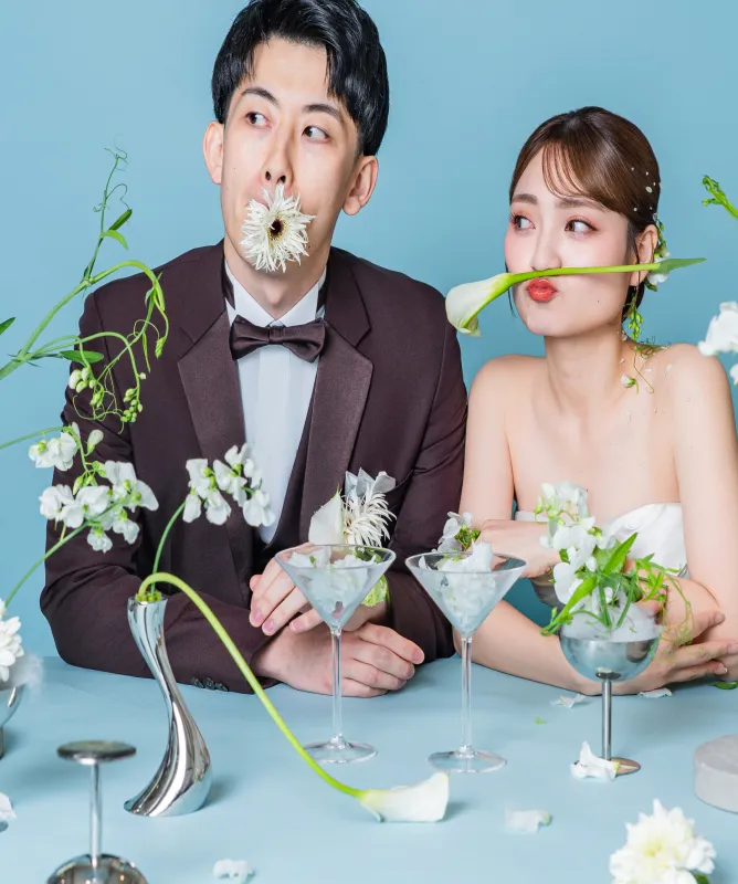 花を口元にあてておどける新郎新婦（Table シーン）